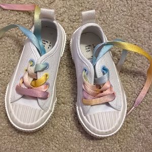White tennis shoes with pastel rainbow shoe laces for toddler girl
